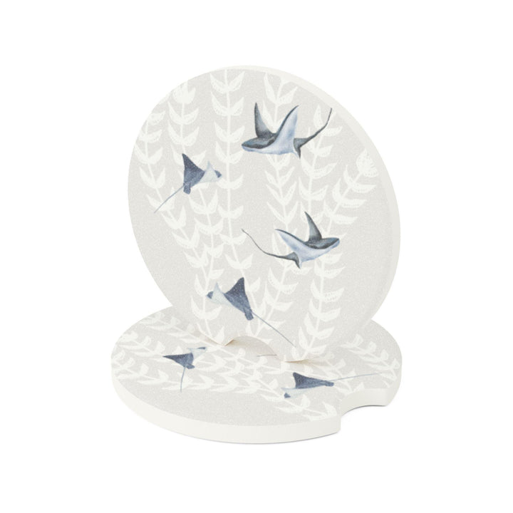 a car's cup holder with two circular coaster covers featuring an abstract sting ray pattern