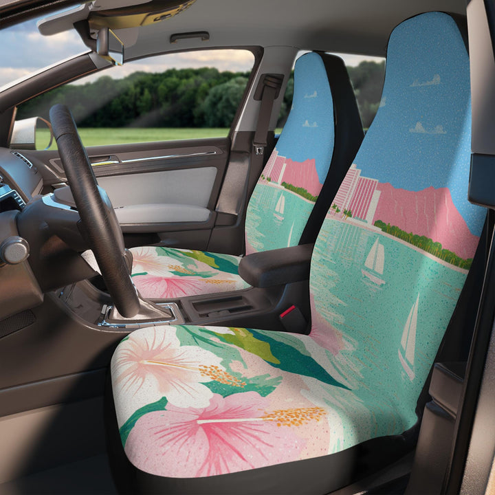 the interior of a car with colorful front seat covers featuring a tropical Hawaiian Waikiki beach scene with palm trees, boats, and mountains.