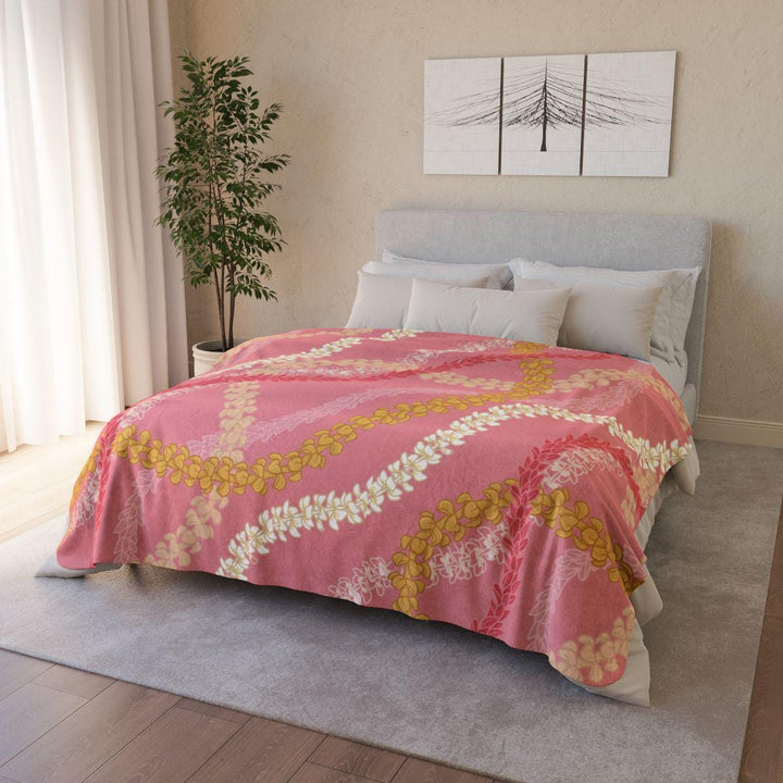 a cozy bedroom with a large bed covered in a pink and yellow floral comforter.