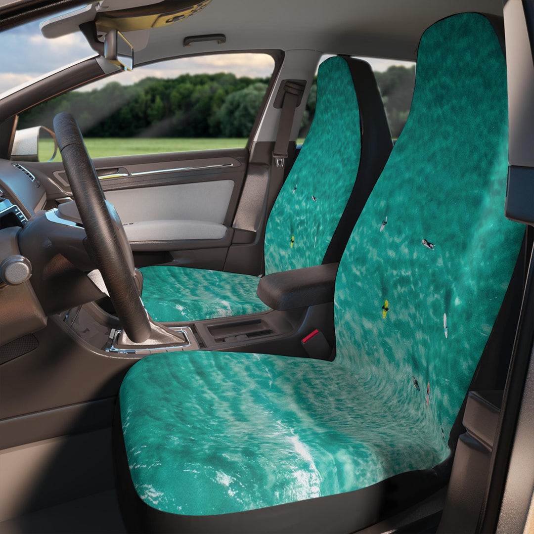 the interior of a car with a steering wheel and seat covers featuring a vibrant turquoise ocean scene.