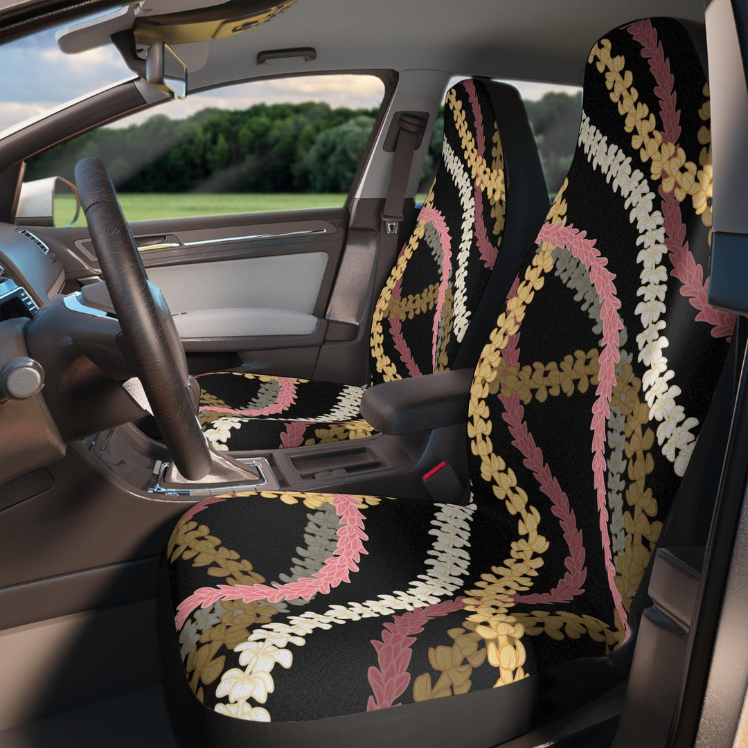 the interior of a car with a patterned seat cover featuring a floral design in shades of pink, black, and white.