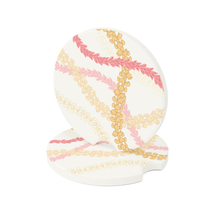 a round coaster with a Hawaiian flower lei floral pattern in pink and yellow colors.