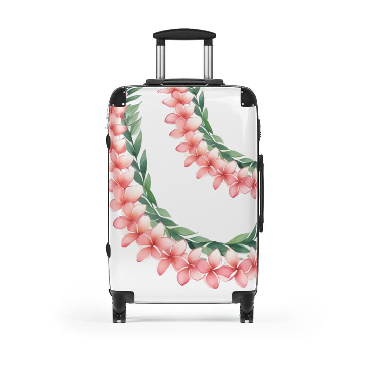 A white suitcase with a Hawaiian flower lei floral design, pink plumeria and green botanical leaves