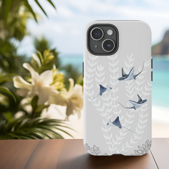 a white phone case with a design of sea creatures, including eagle rays swimming through sea plants.