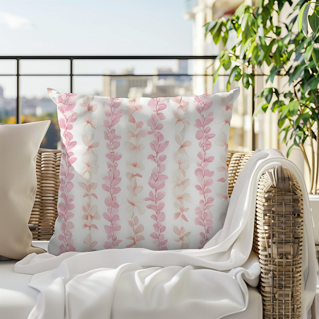 a white pillow adorned with pink and white floral patterns.