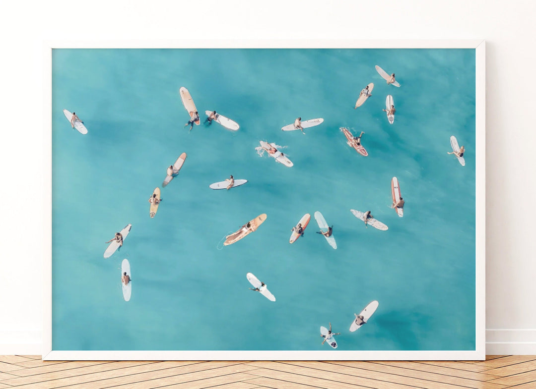 a group of surfers riding on surfboards in the ocean, with a blue sky and water background.