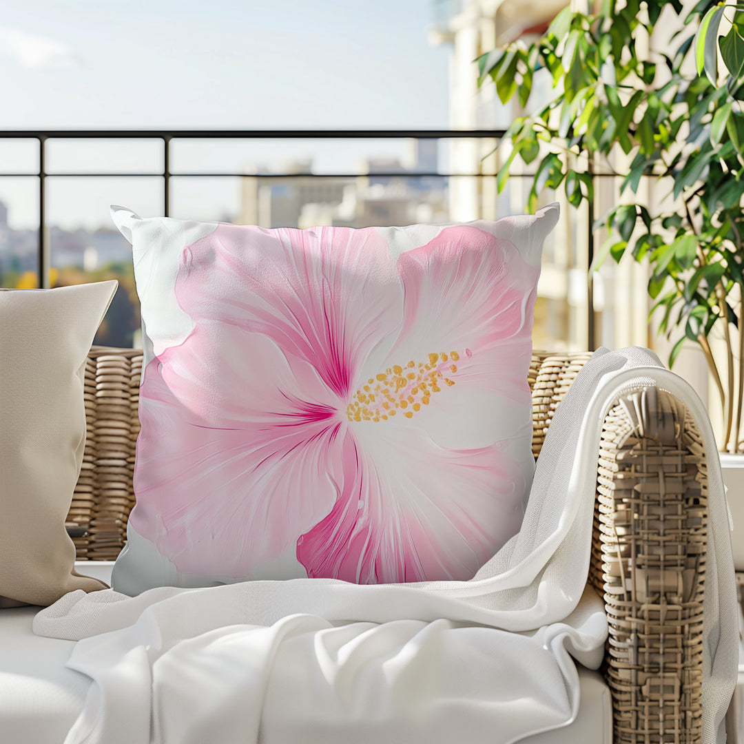 A large, vibrant pink hibiscus flower with yellow centers is displayed on a white pillow