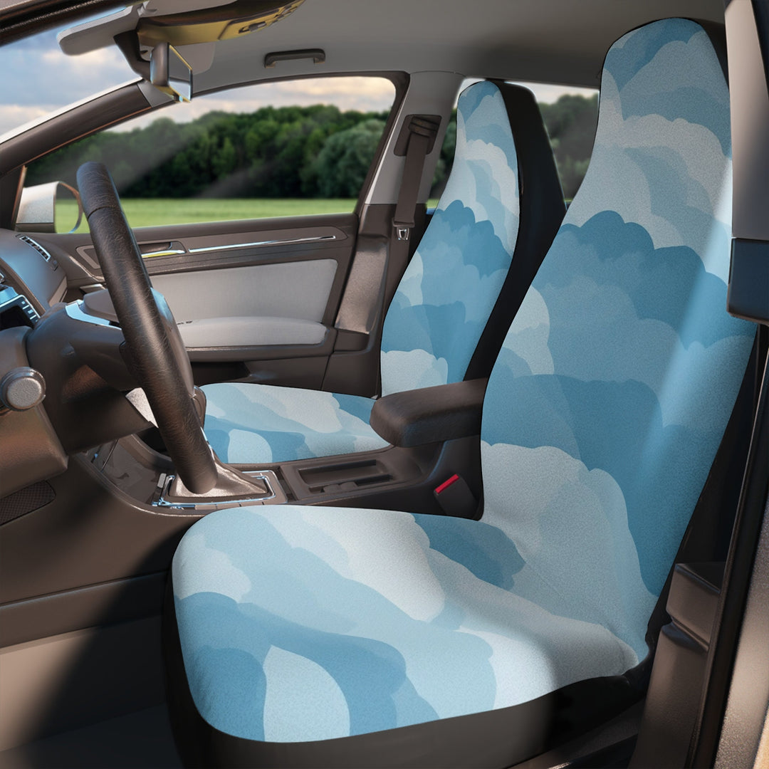 the interior of a car with a patterned seat cover featuring a cloud design in shades of blue and gray.