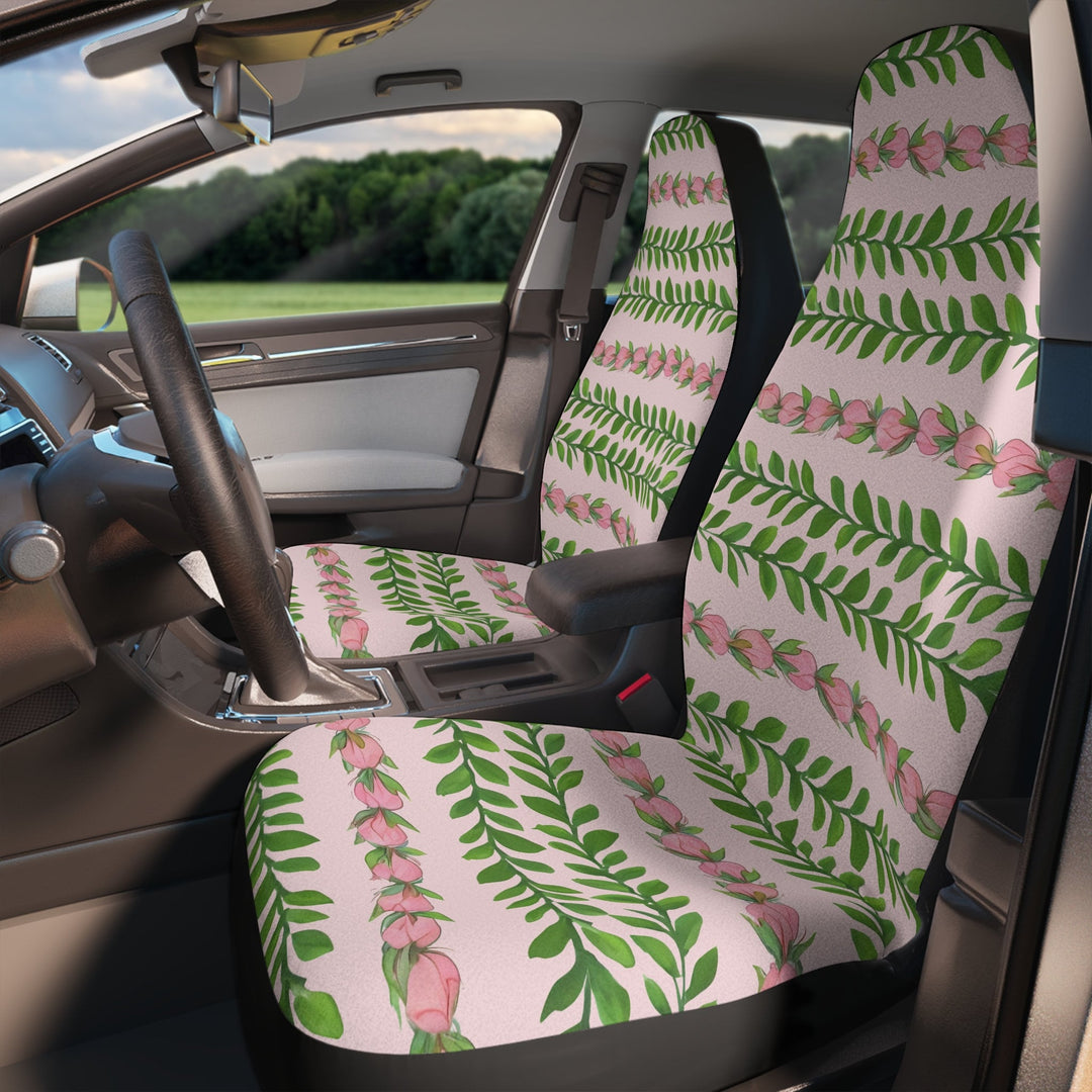 the interior of a car with a patterned seat cover featuring green leaves and pink flowers in the pattern of a flower lei