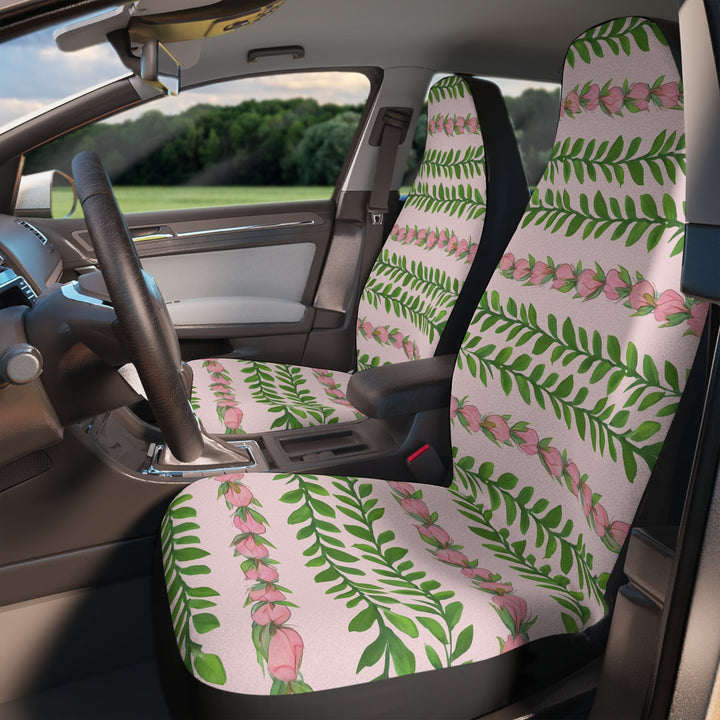 the interior of a car with a patterned seat cover featuring green leaves and pink flowers in the pattern of a flower lei